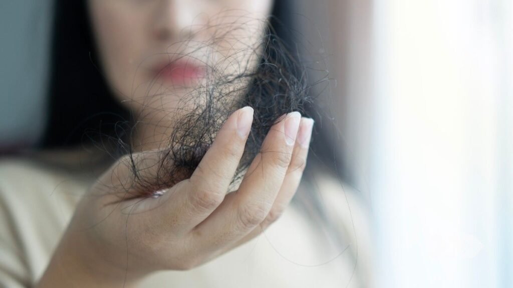 A girl with hairs in hand facing hair lose issue.