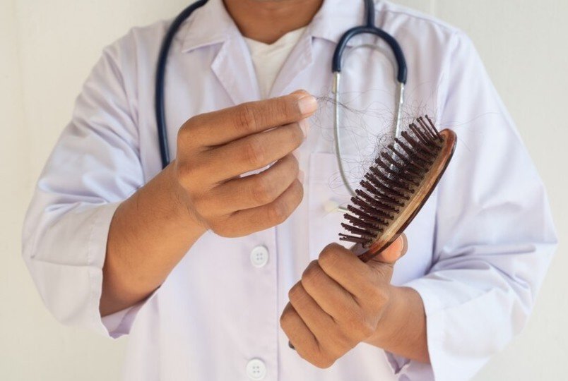 A doctor is examining the hair brush to prove hair loss.
