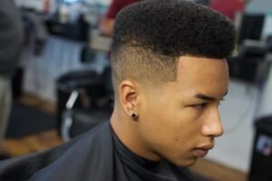 A handsome guy with skin fade haircut sitting on barber chair