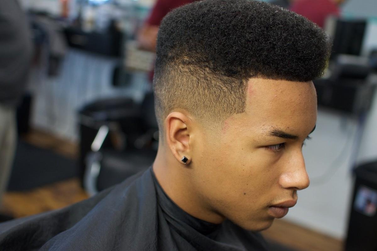 A handsome guy with skin fade haircut sitting on barber chair