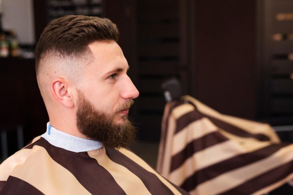 A you man sitting on barber chair with medium skin fade