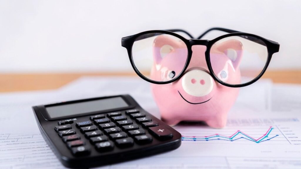 Pink piggy bank, calculator Stacked on financial documents, growth graphs