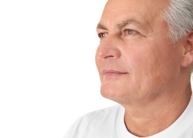 An aged man in white shirt with lines on neck