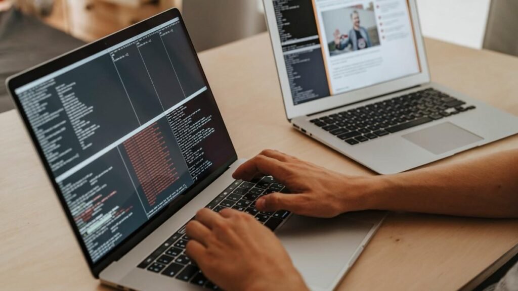 A programmer doing coding on laptop