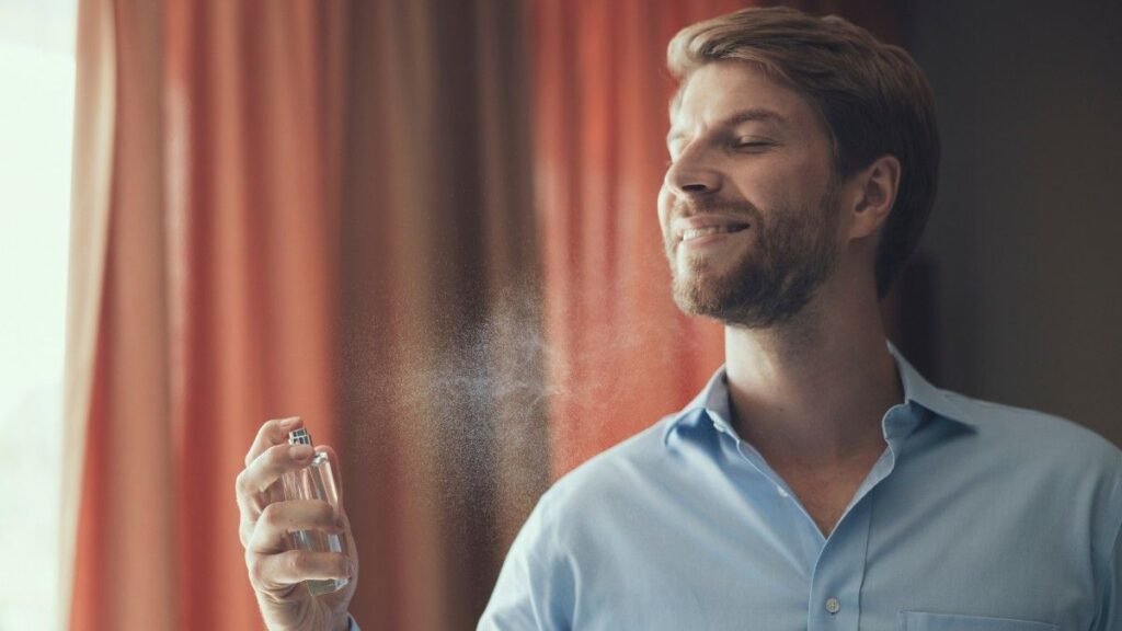 Happy man enjoying fragrance of his new perfume