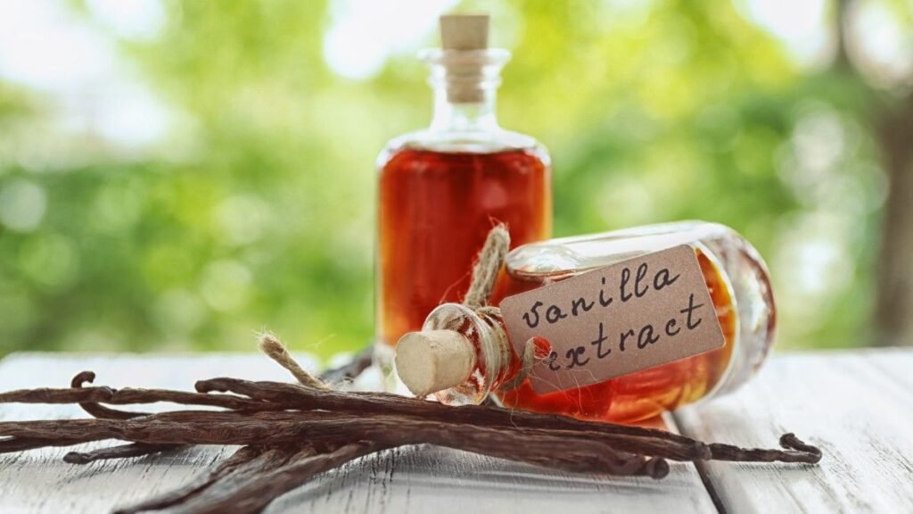 Bottles with Vanilla Extract and Dry Vanilla Beans on Table