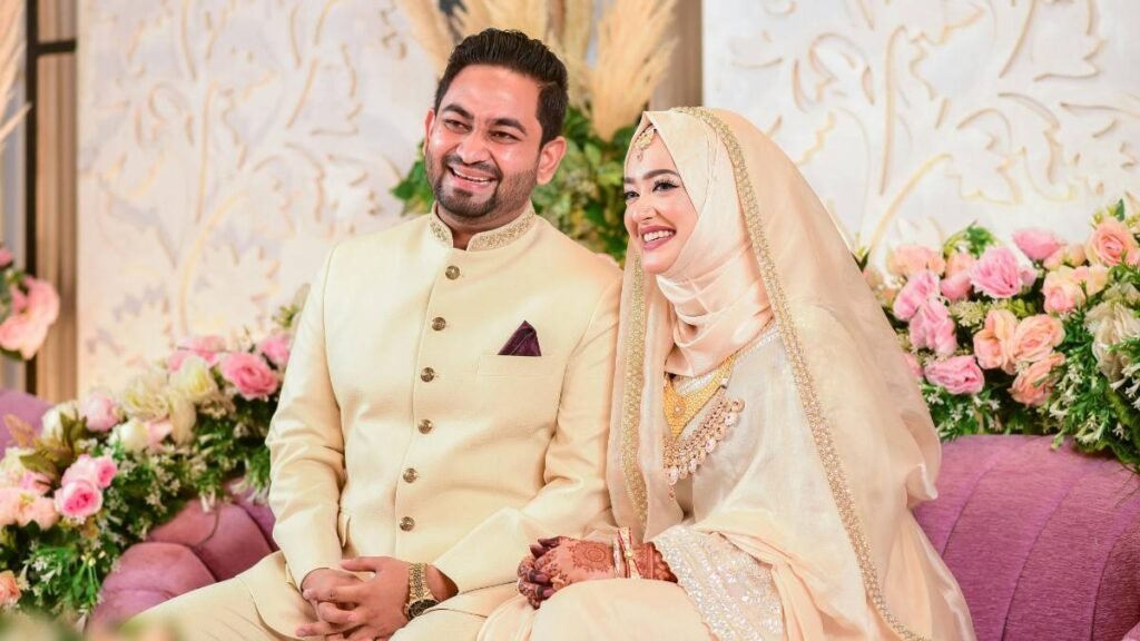 Muslim bride and groom setting on sofa in Wedding