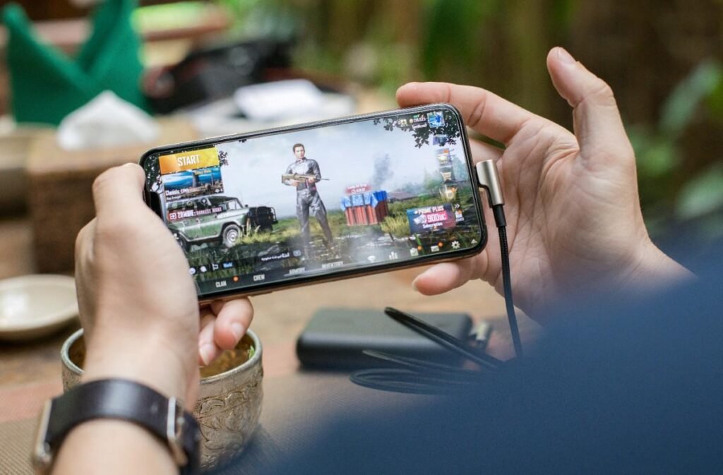 A mobile in the hand of man playing PUBG mobile game