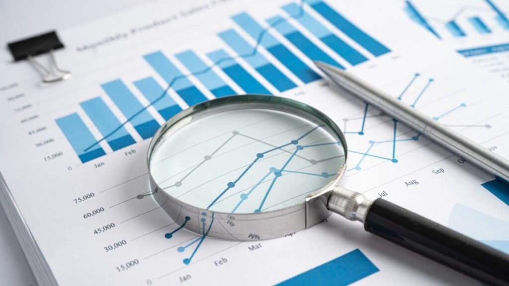 Magnifying Glass on Charts Graphs Paper. Financial Development.