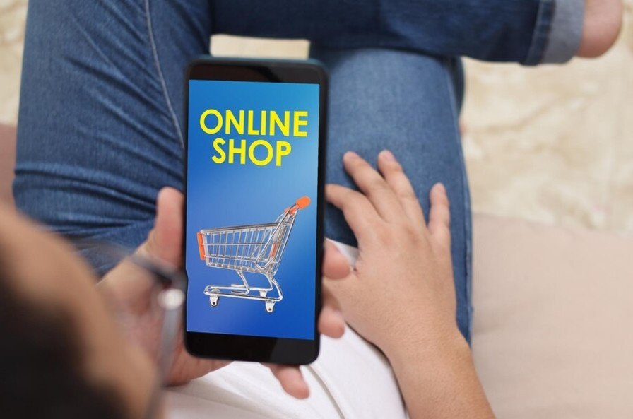 A man holding phone on which online shopping app is opened