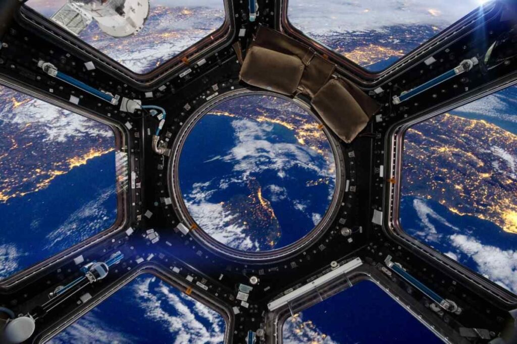 View from a porthole of space station on the Earth background