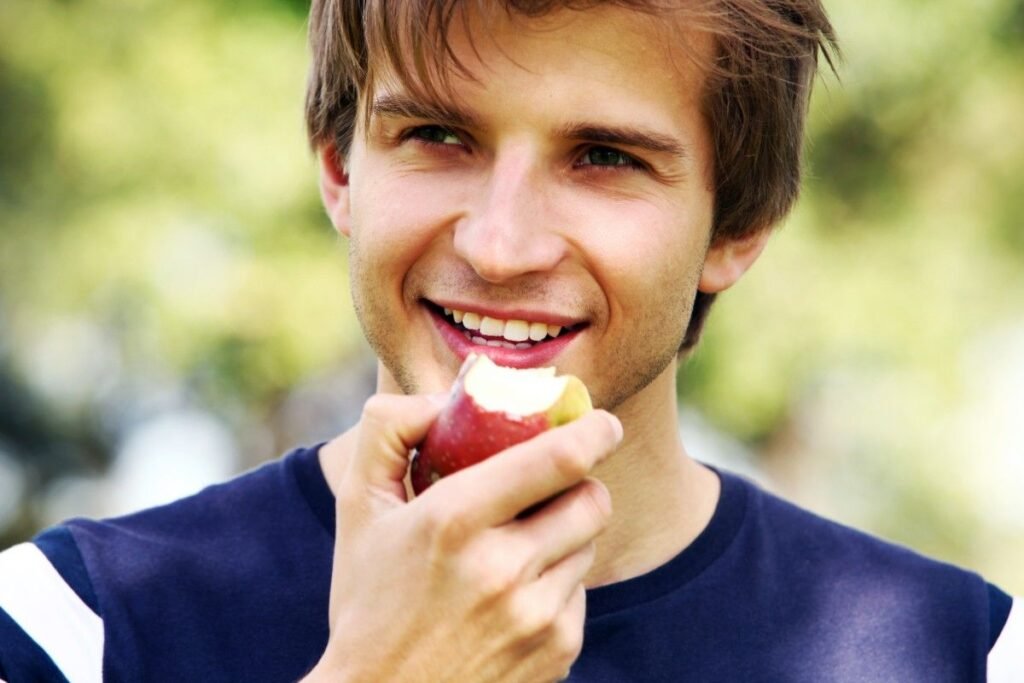 A young man eating apple.