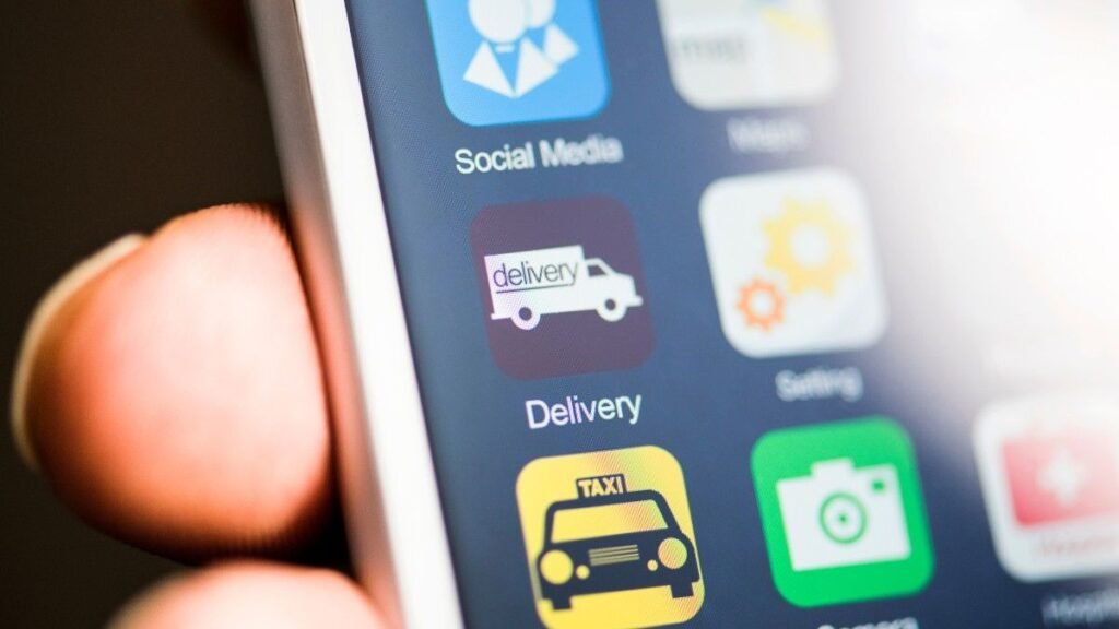 Hand holding phone, delivery app on screen
